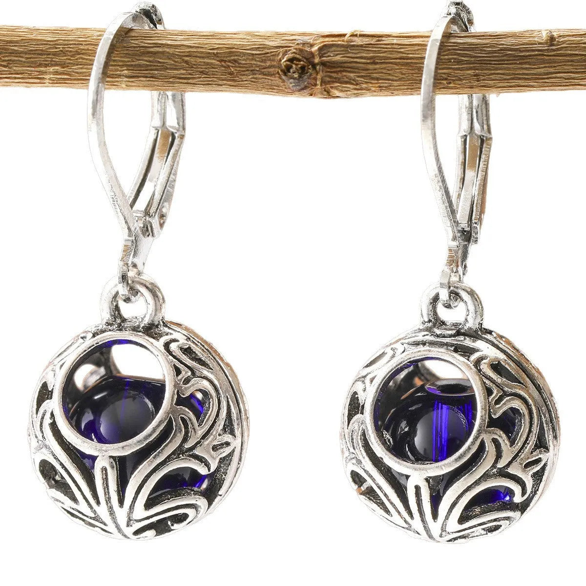 Silver tone pendant earrings with hollow geometric design, blue gemstones, and vintage engraving detail