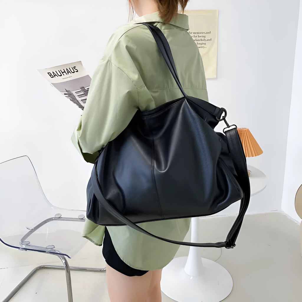 Large black PU leather messenger bag with shoulder strap showing internal organisation pockets