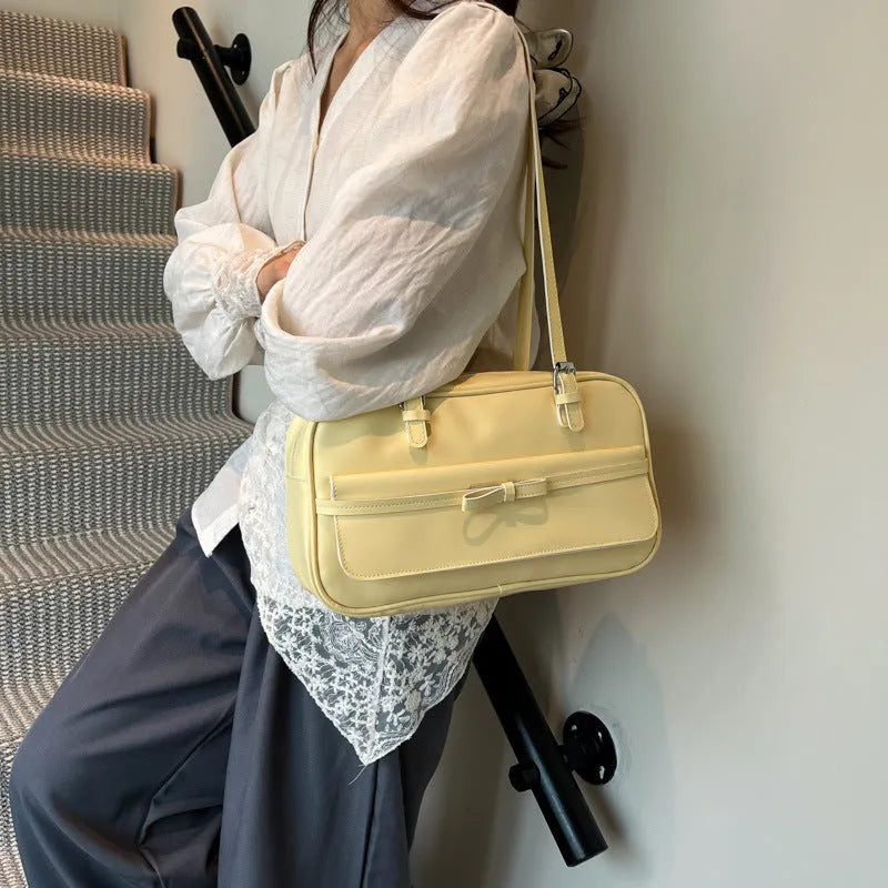 Single-shoulder flap bag in horizontal square shape with bow decoration and internal phone compartment