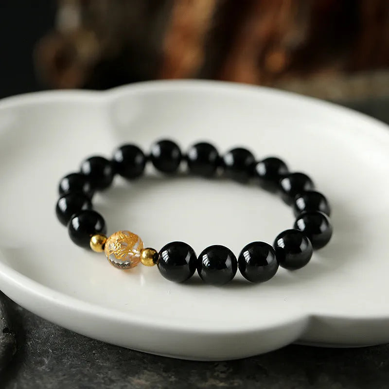 Geometric obsidian and white crystal beaded bracelet with golden dragon charm on adjustable band