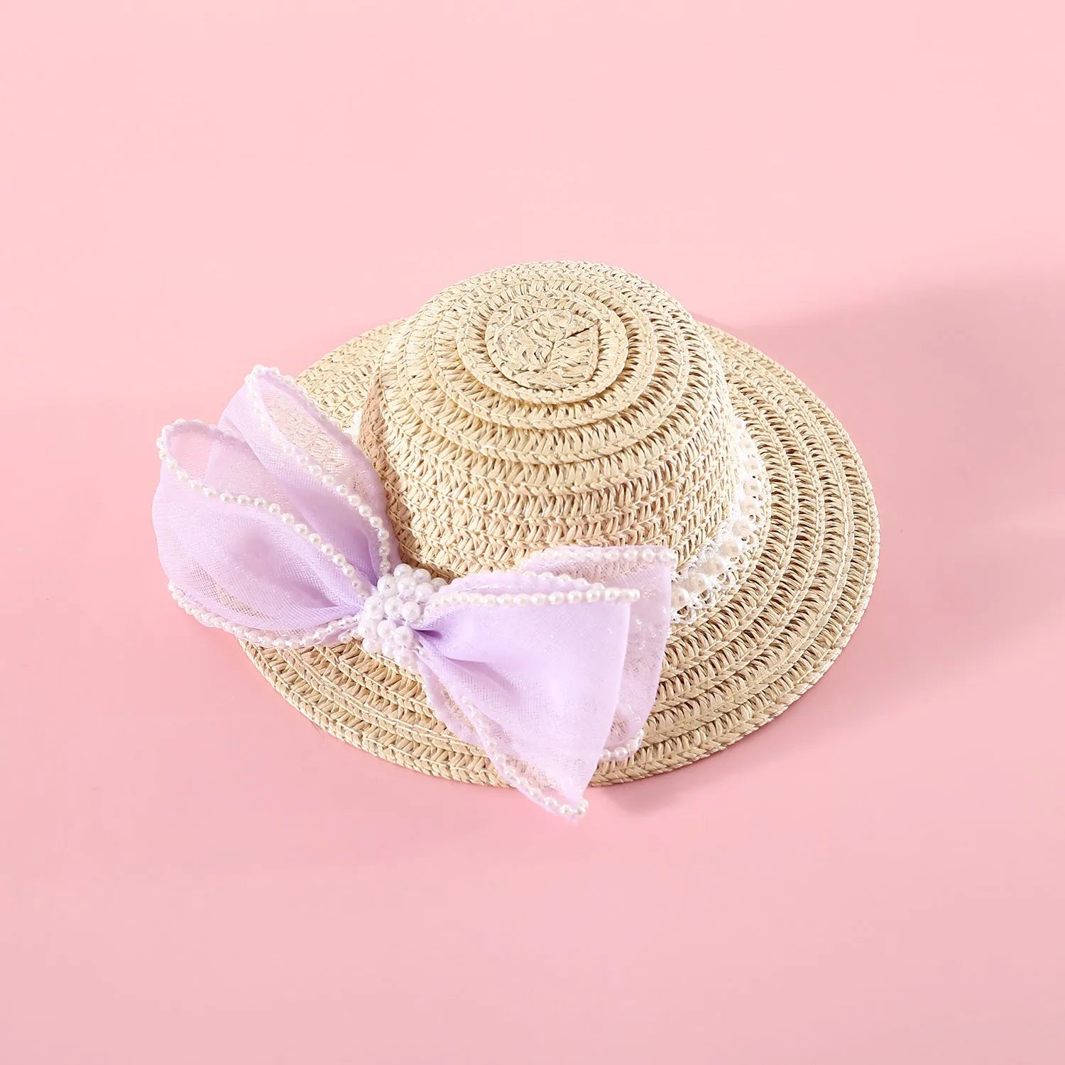 A woven Lafite leaf straw hat for a cat, decorated with a pearl butterfly bow, shown in pink, purple, blue, and white colour options.