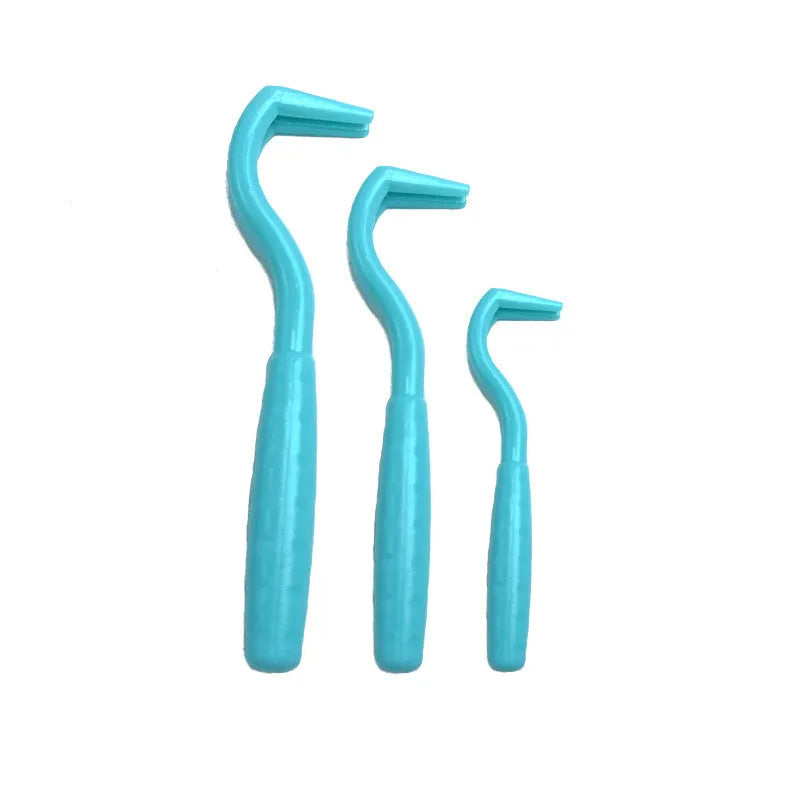 Three plastic tick removal hooks for dogs, shown in assorted colours on a white background.