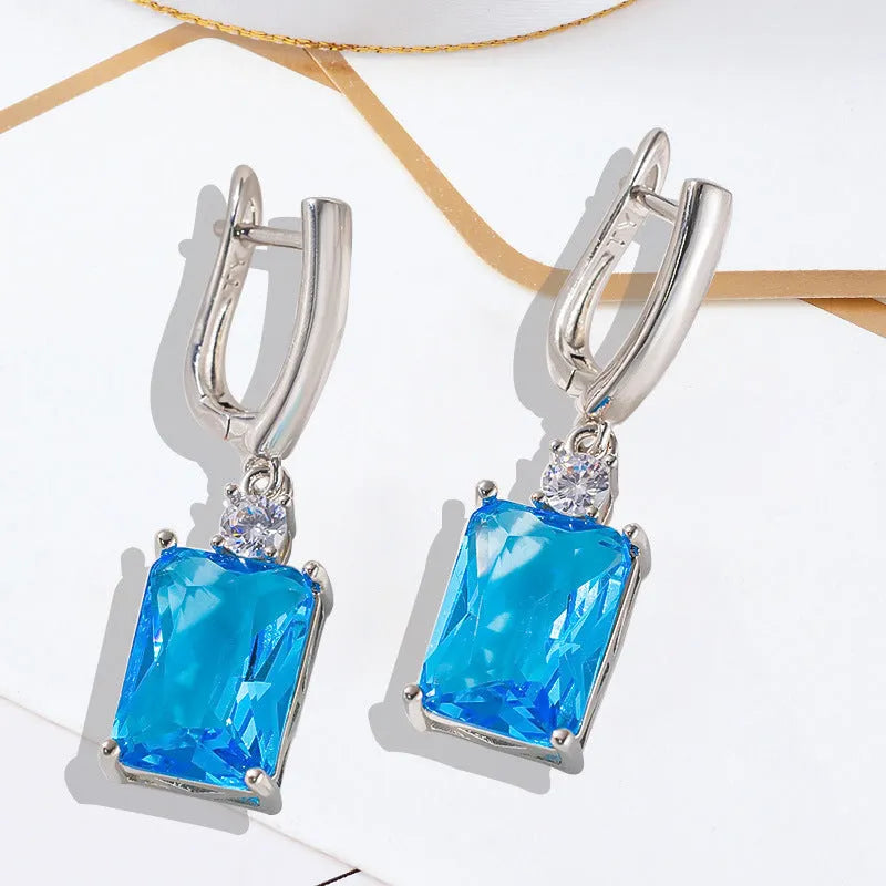 A pair of square geometric earrings with a quadrilateral design in a gold or silver electroplated finish.