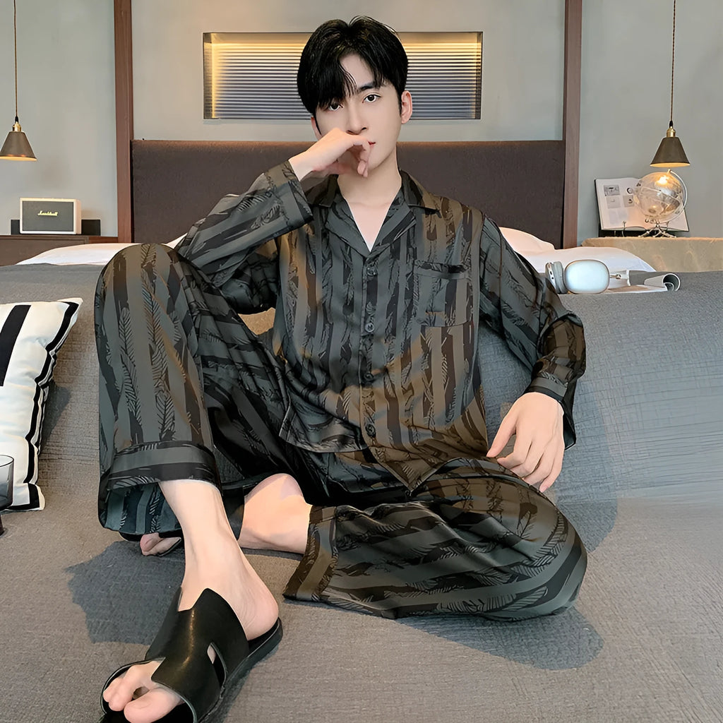 Men's black striped Ice Silk long sleeve V-neck pajama top and thin trousers set laid flat.