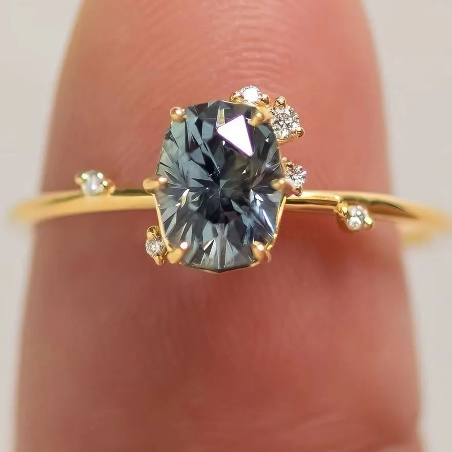 Gold-plated women's ring with green zircon stones and floral engraving on a white background.