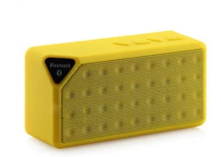 Cannon X3 small cube-shaped portable Bluetooth speaker in multiple colours on a table