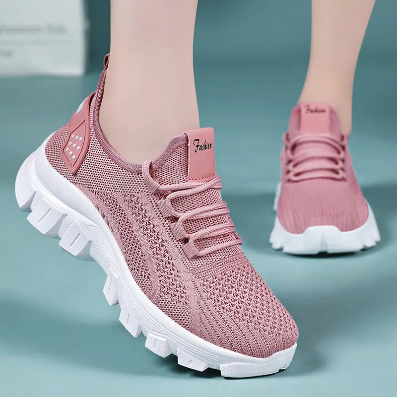 Women's white flyknit casual sneakers with thick PVC sole and round toe, showing lace-up front.