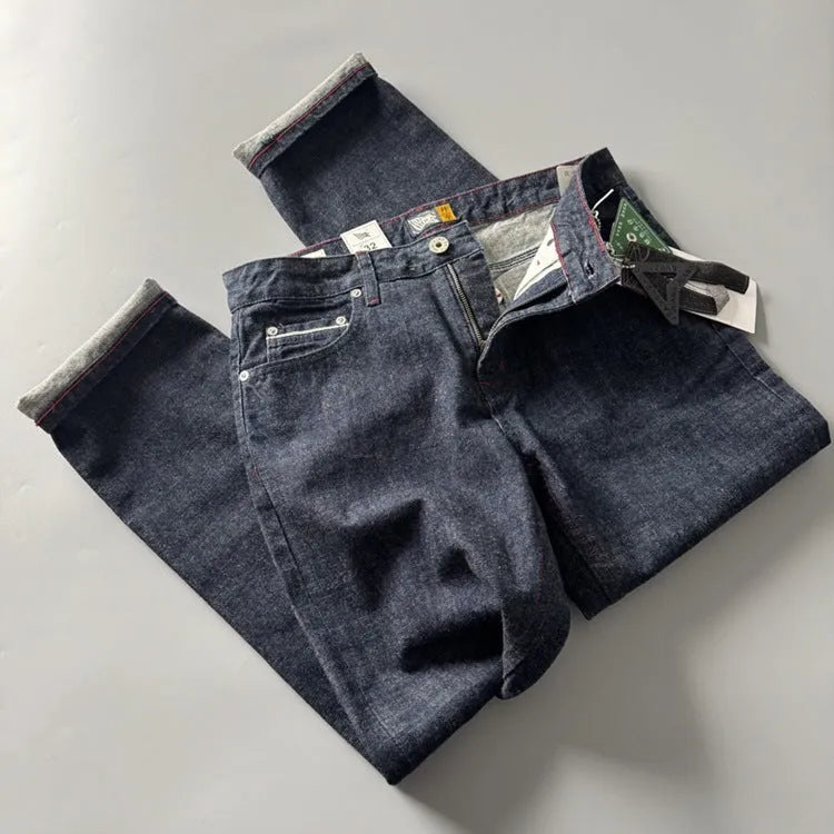 Men's straight leg denim trousers in a primary blue wash, showing front view on a hanger.