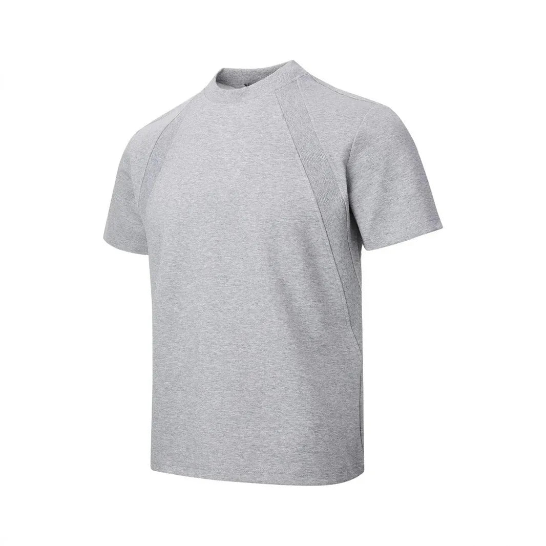 Man wearing a loose-fit grey short sleeve polyester top with air layer stitching.