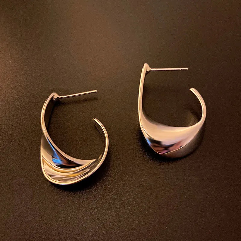 Metal twisted geometric earrings with round shape in gold or silver electroplated finish