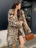 A woman wearing a long plush faux fur coat with a detachable fur collar and pockets, shown in a street fashion setting.