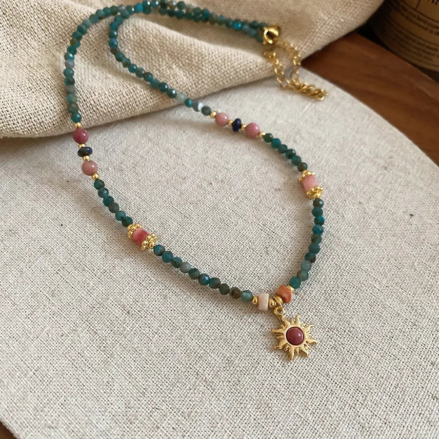 Stone sun pendant and freshwater pearl French court style necklace on a model