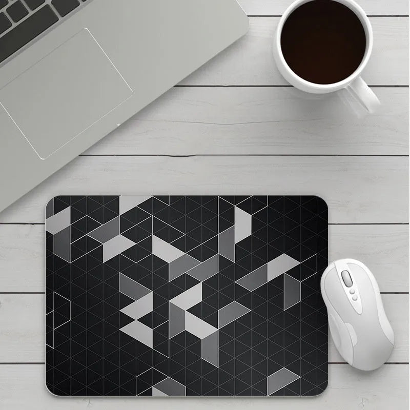 Custom cartoon design on a small black thickened mouse pad with stitching, shown on a desk.