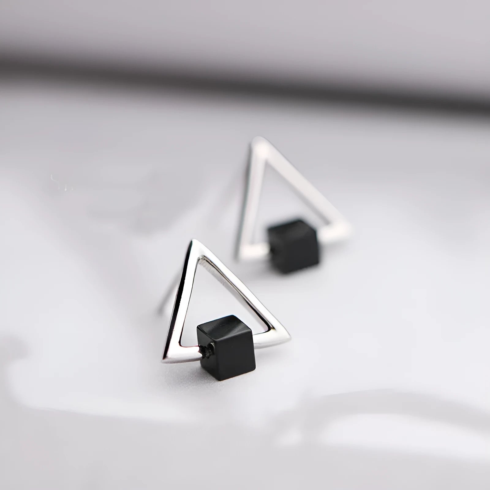 Sterling silver S925 geometric triangle black earrings with gem inlay on neutral background