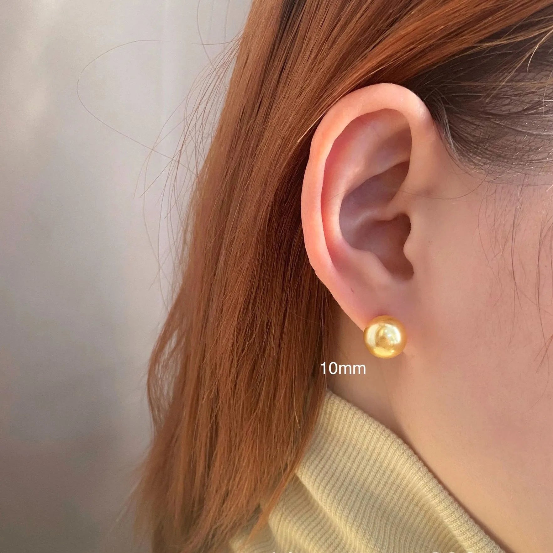 A pair of large geometric silver stud earrings with a central pearl and an eight-point star design detail.