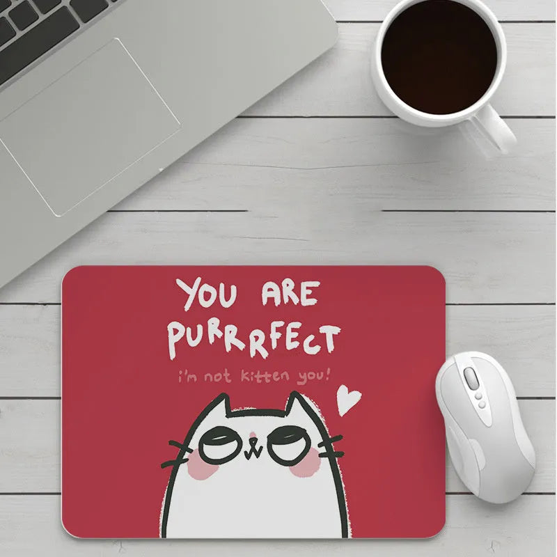 Custom cartoon design on a small black thickened mouse pad with stitching, shown on a desk.