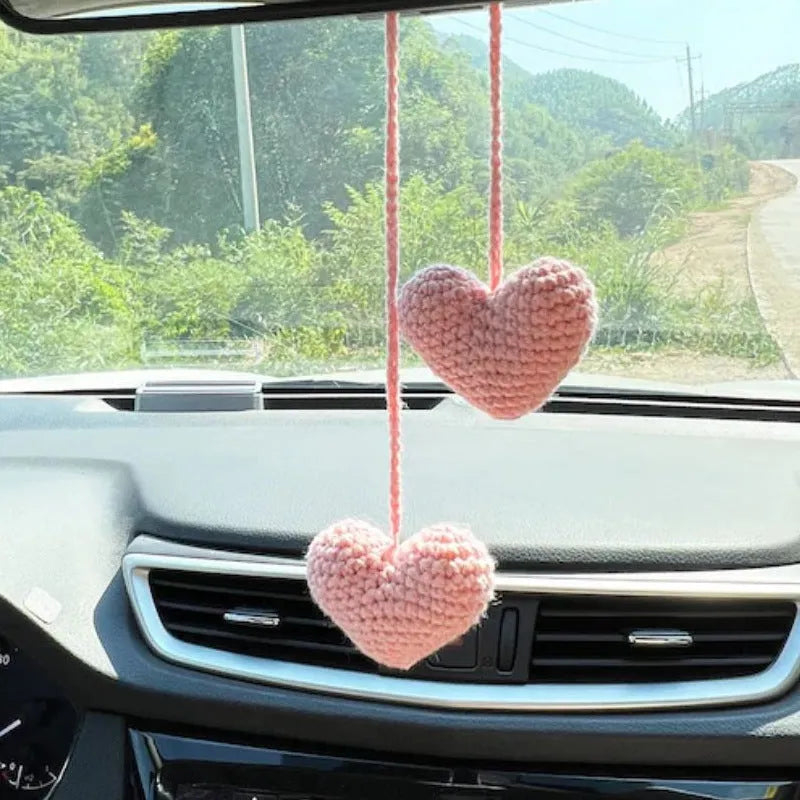 Green and white crochet wool car plant decoration with hanging rope on car dashboard