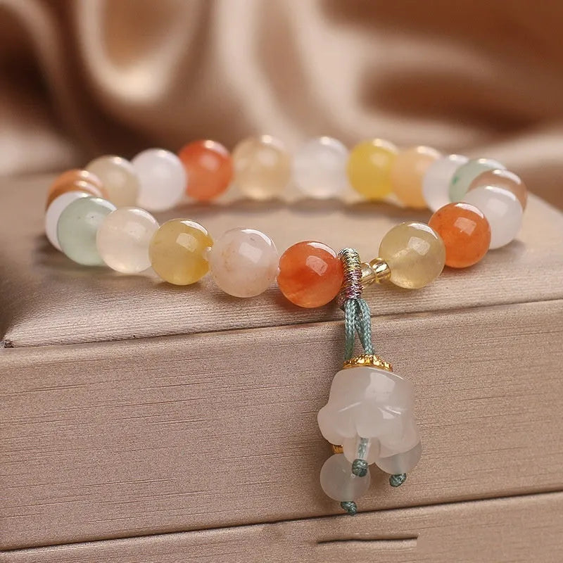 Natural Jinsi Jade round bead beaded bracelet with lily pendant on neutral background