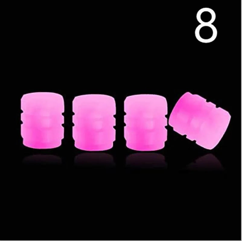 Pack of green and blue luminous rubber tyre valve caps on a car tyre valve.