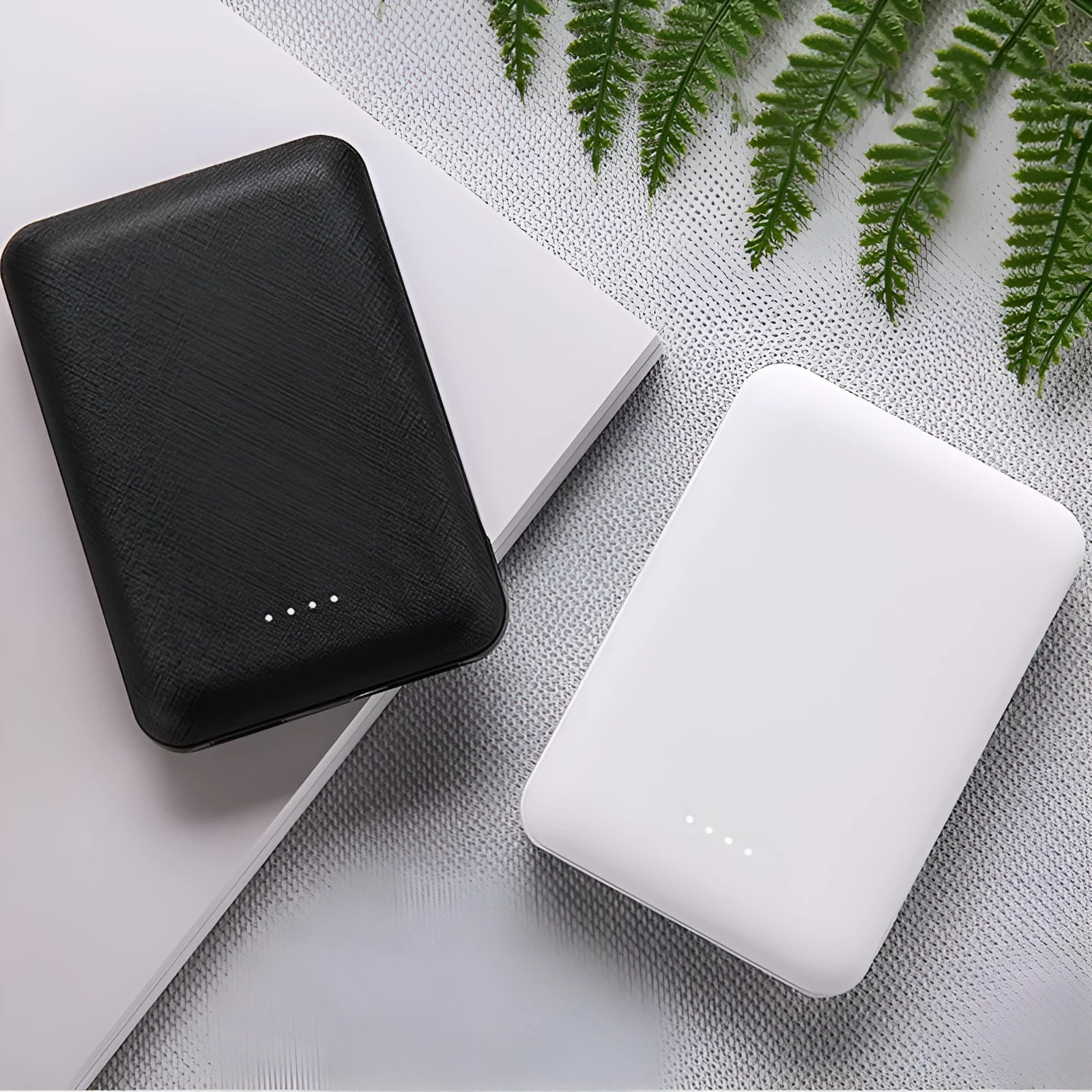 Black and white ultra-thin 10,000mAh power bank showing compact 90x63x22mm dimensions