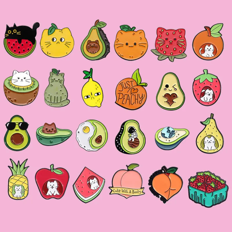 Colourful cartoon fruit design metal brooch with pin back on a fabric background.