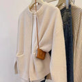Beige viscose knit long sleeve cardigan sweater coat on a hanger
