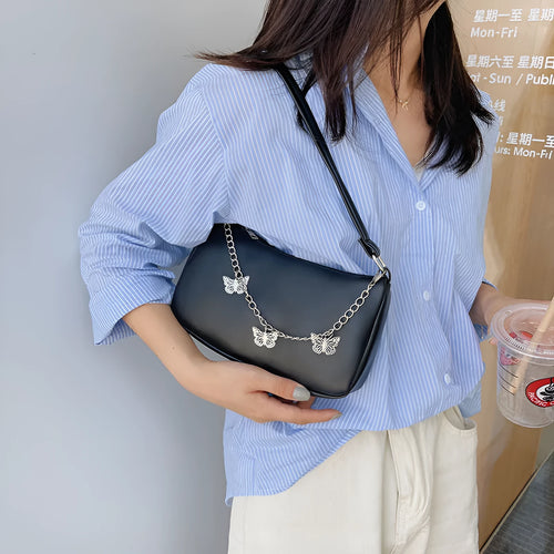 Square black PU leather crossbody bag with a butterfly chain strap and external structured pocket.