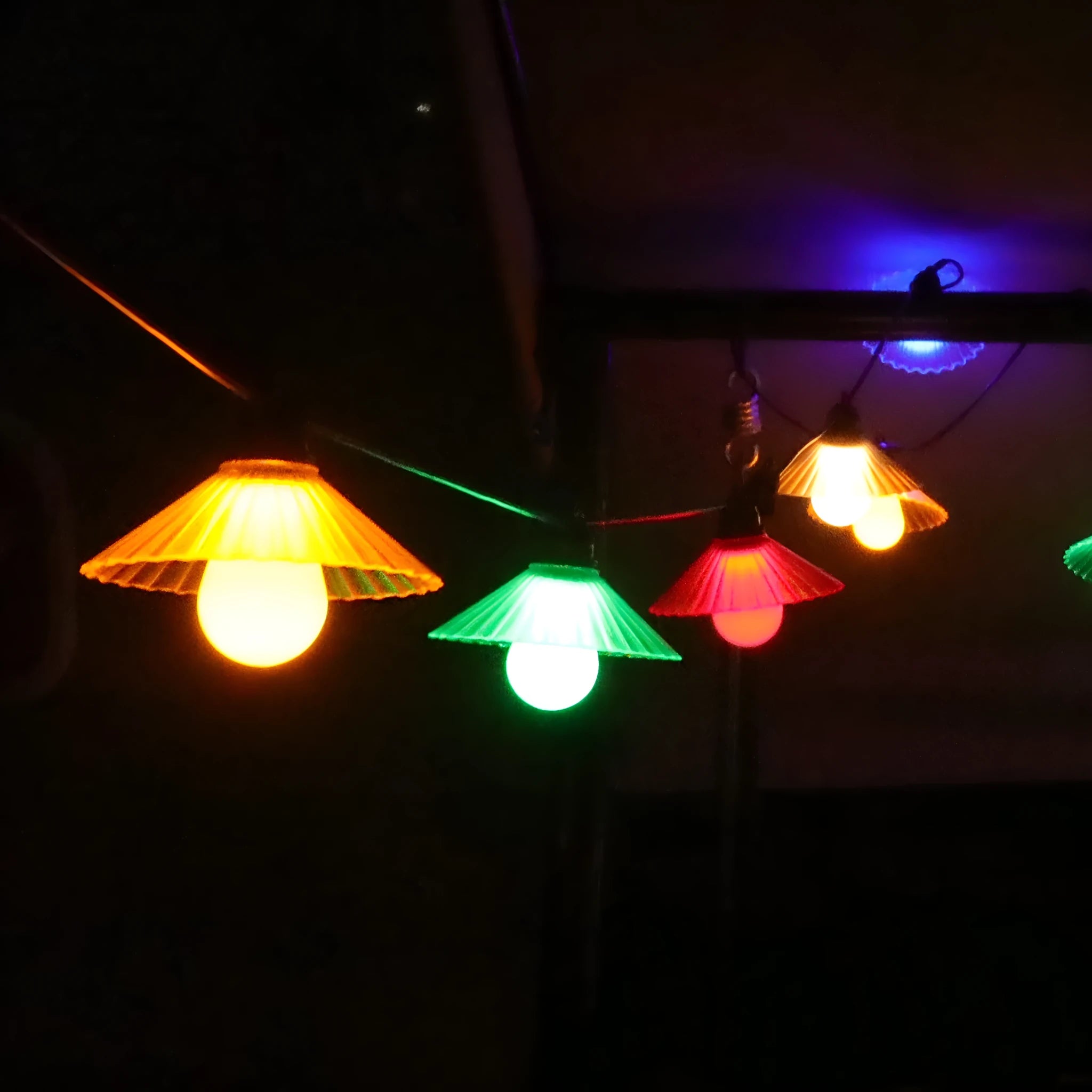Outdoor LED string lights with flower-shaped bulbs in warm white and multicolour settings.