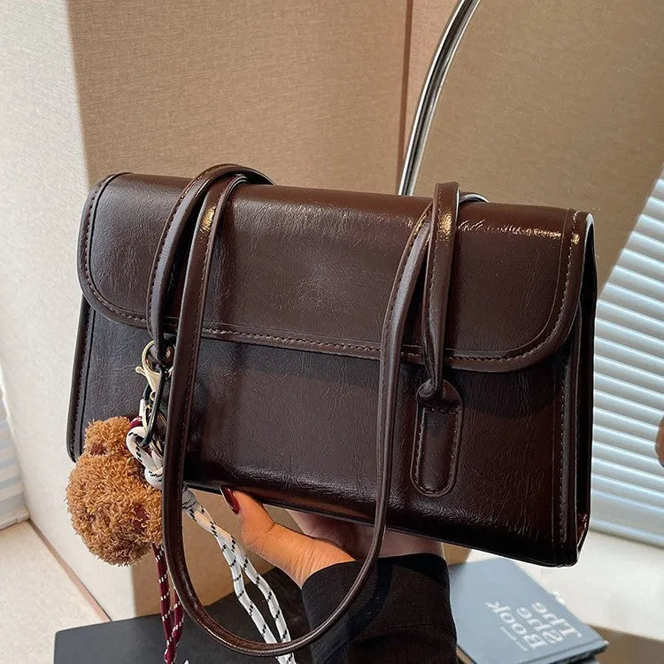 Brown women's PU leather shoulder bag with a square shape, double straps, and a detachable pendant.