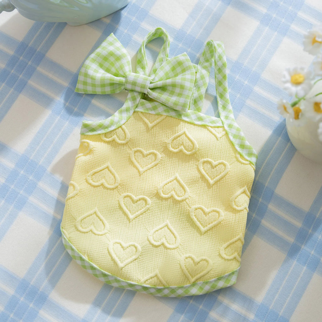 Small dog wearing heart bow suspenders vest in elastic material with decorative bow detail