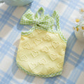 Small dog wearing heart bow suspenders vest in elastic material with decorative bow detail