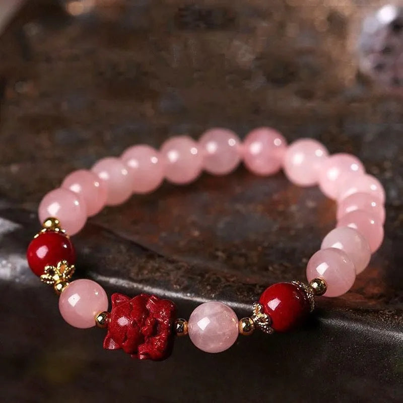 Aquamarine crystal bracelet with mixed materials including pink beads, white pearls, and peach blossom elements
