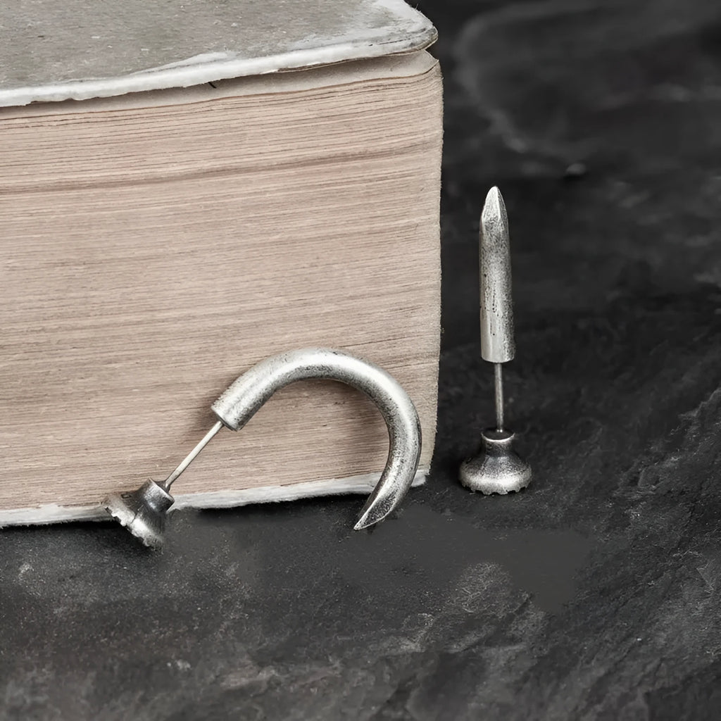 Close-up of a sterling silver S925 punk-style earring shaped like a retro nail, shown on a hook back.