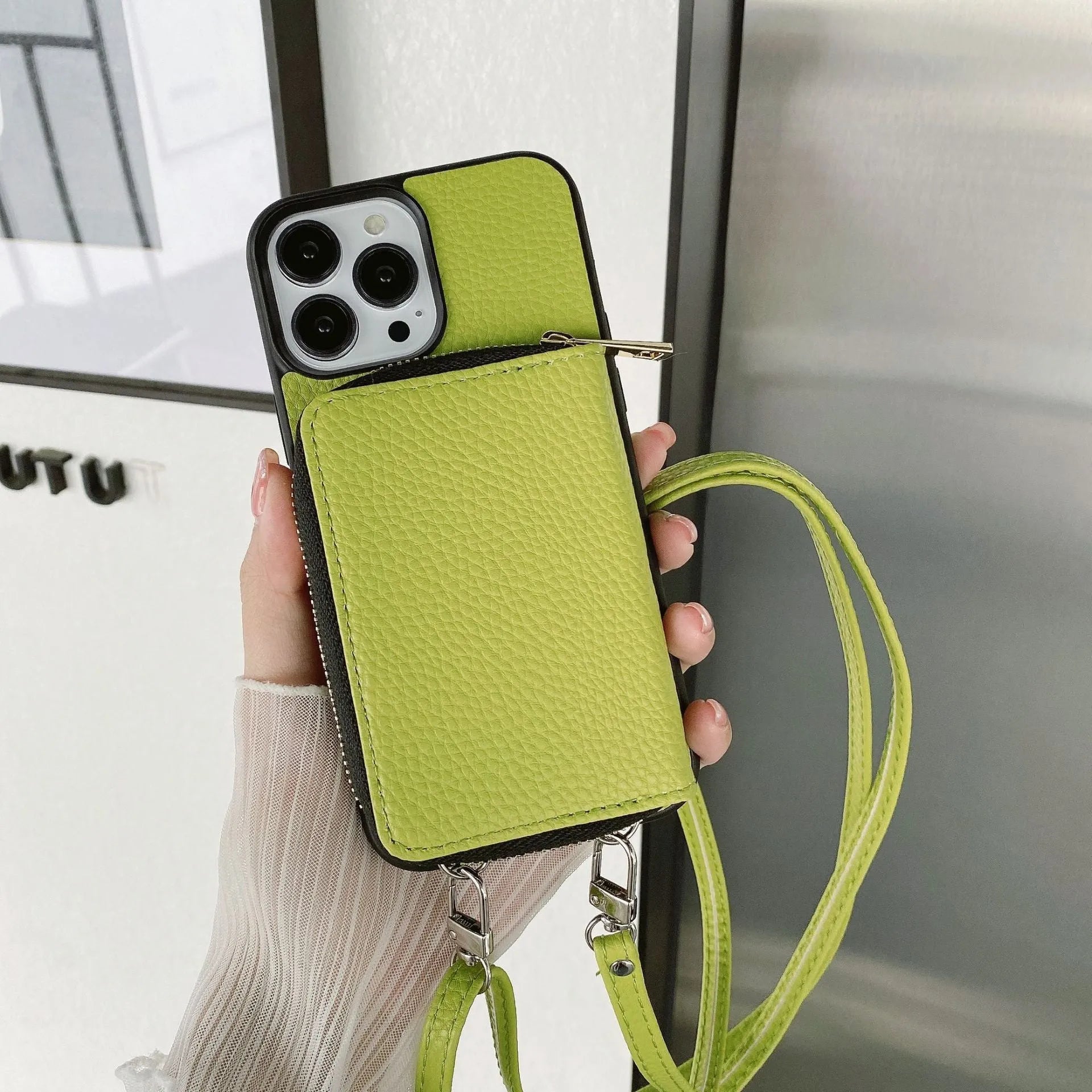 Litchi patterned protective case for iPhone on a table, showing Black and Grass Green colour options.