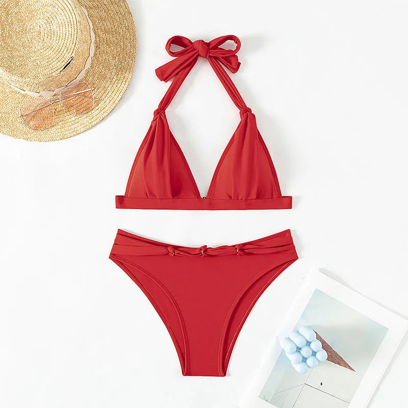 Red women's lace-up halterneck bikini set with matching shorts on a plain background.