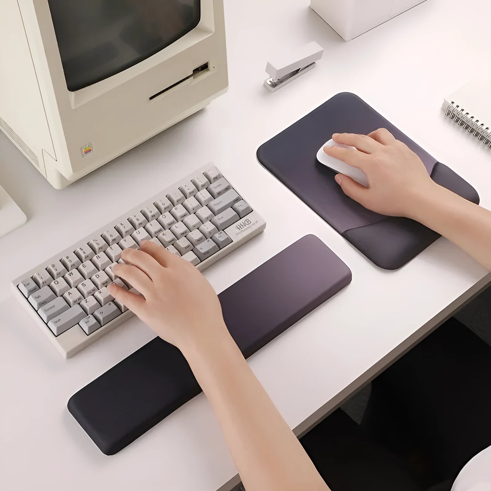 Square silicone wrist rest mouse pad with wrist strap in multiple colour options on a desk