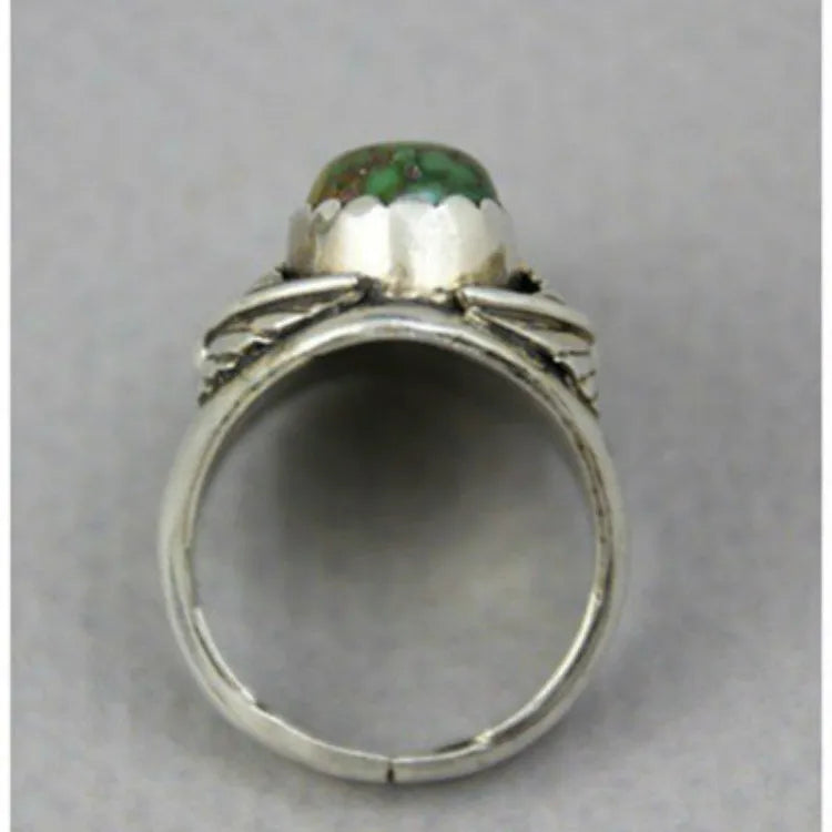 Close-up of a women's turquoise geometric ring with retro inlaid design on a hand.