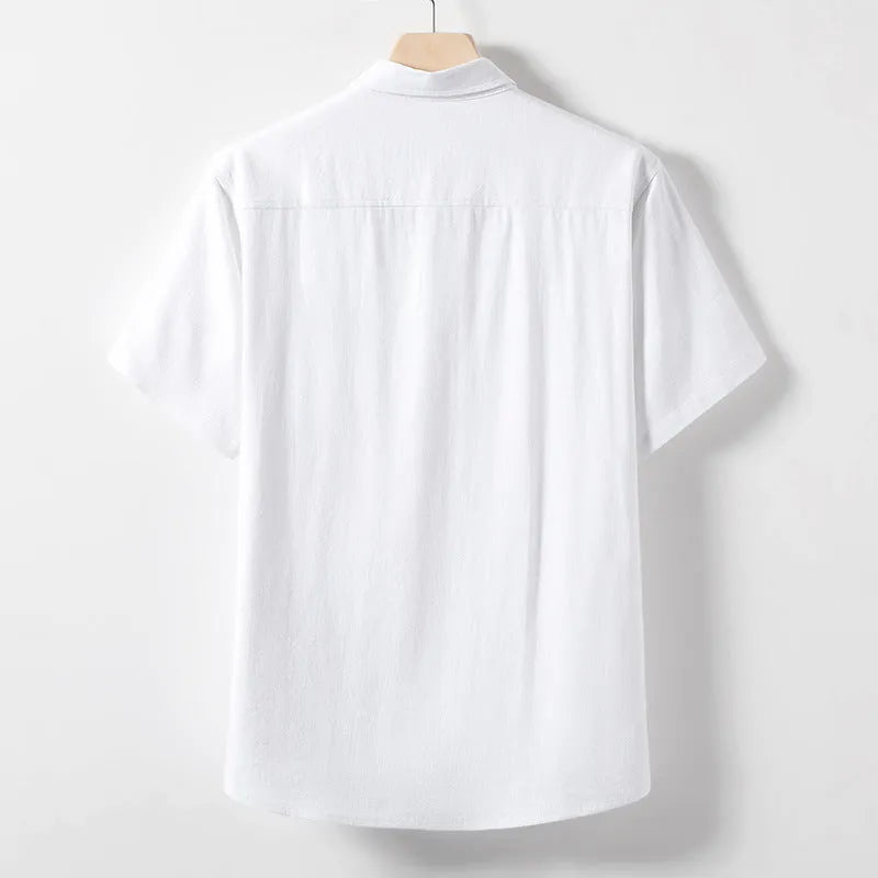 A man wearing a loose-fit linen-blend t-shirt in a solid colour with a relaxed lapel and short sleeves.