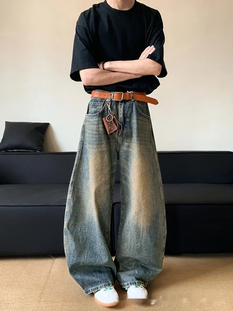 Man wearing retro blue distressed wide-leg denim trousers with a slimming fit.