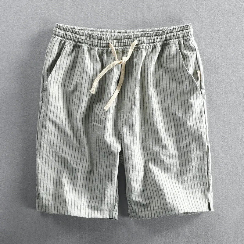 Man wearing black and white striped cotton casual shorts with a loose straight leg and elasticated waist.