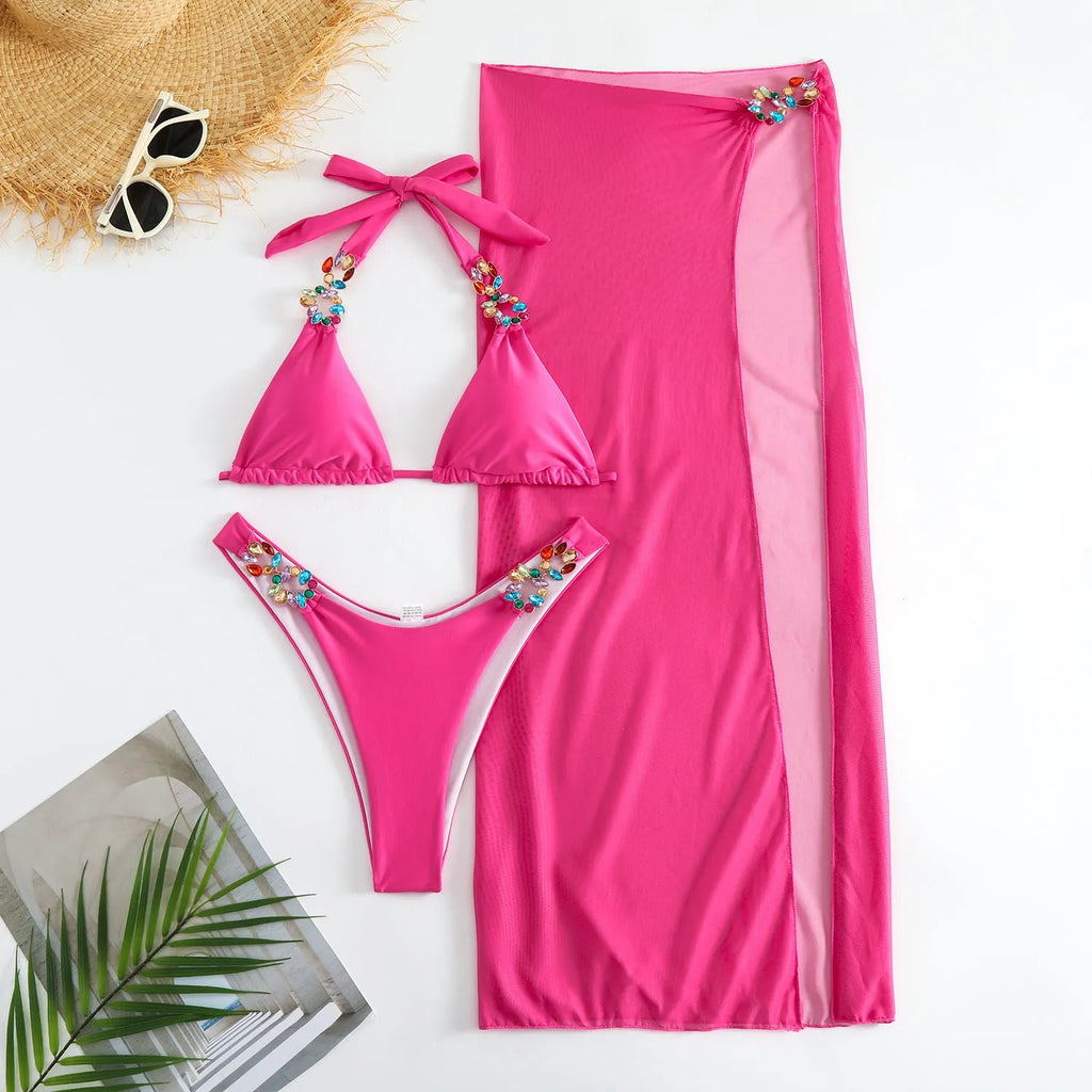 Rose red mesh long skirt three-piece bikini swimsuit set laid flat.