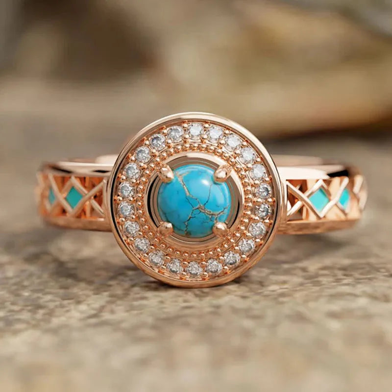 Women's rose gold coloured copper ring with geometric shape and inlaid turquoise zircon stones.
