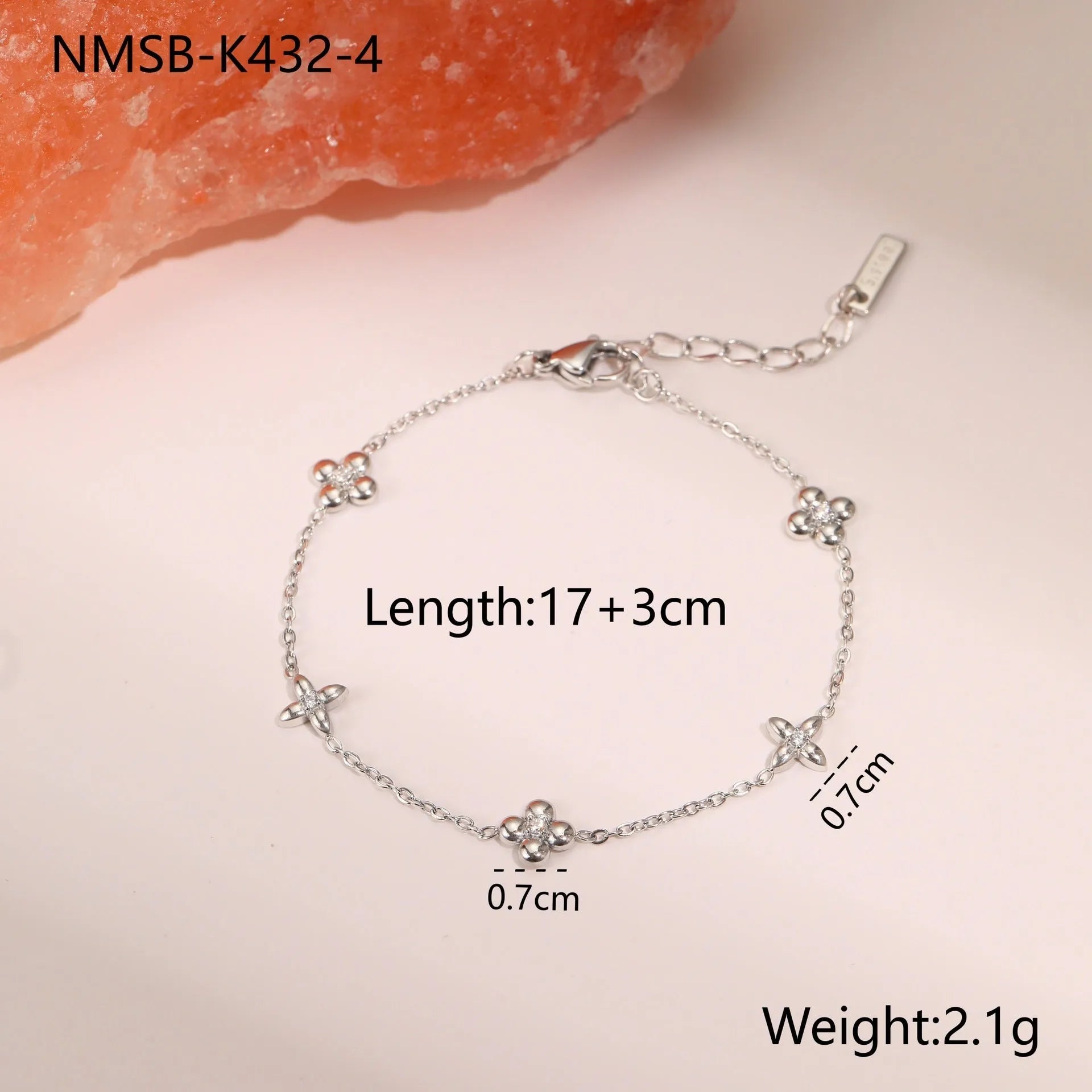Gold plated stainless steel bracelet with a detailed zircon star pendant on a woman's wrist.