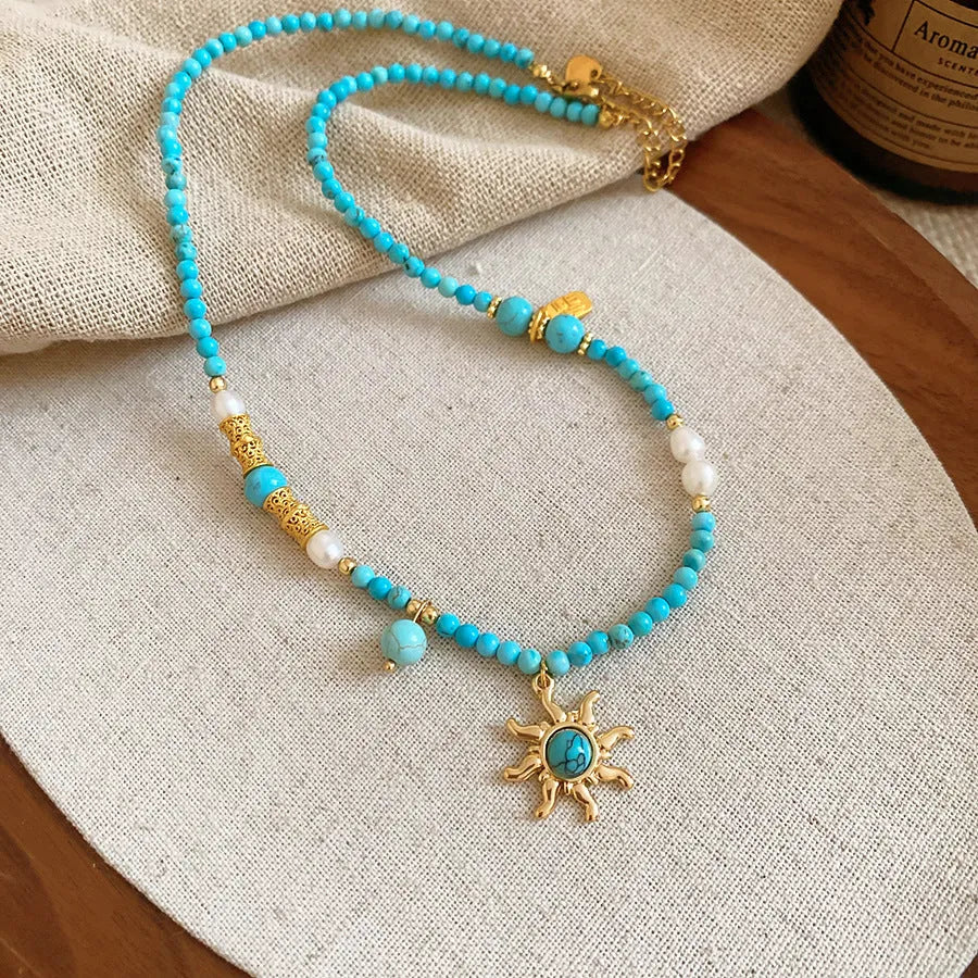 Stone sun pendant and freshwater pearl French court style necklace on a model