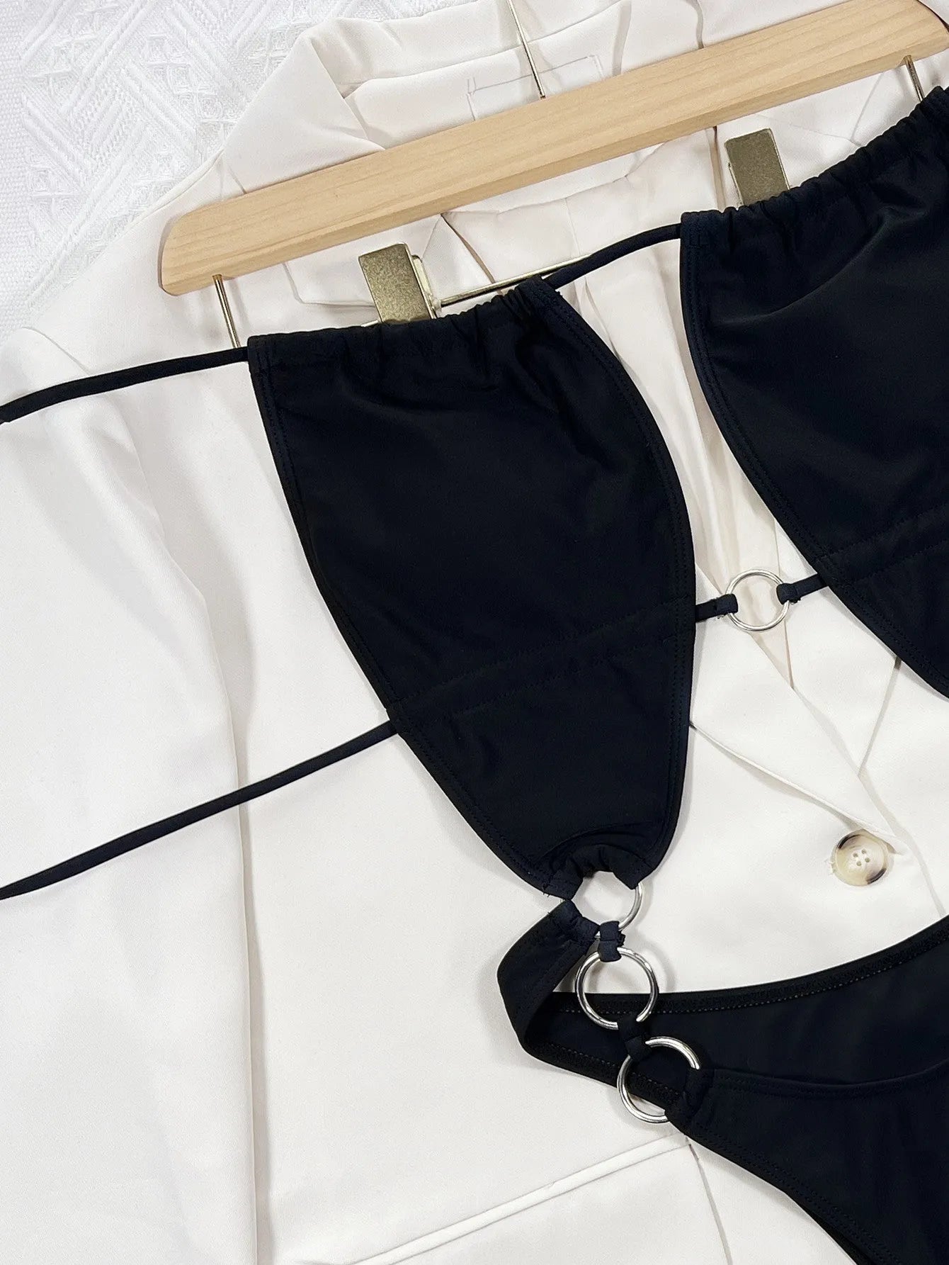 Black women's one-piece swimsuit on hanger showing sleeveless design