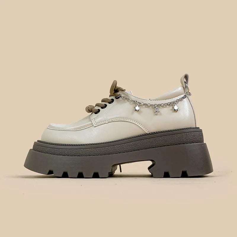 White platform Mary Jane shoes with chunky heel and metal decorations on display
