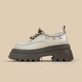 White platform Mary Jane shoes with chunky heel and metal decorations on display