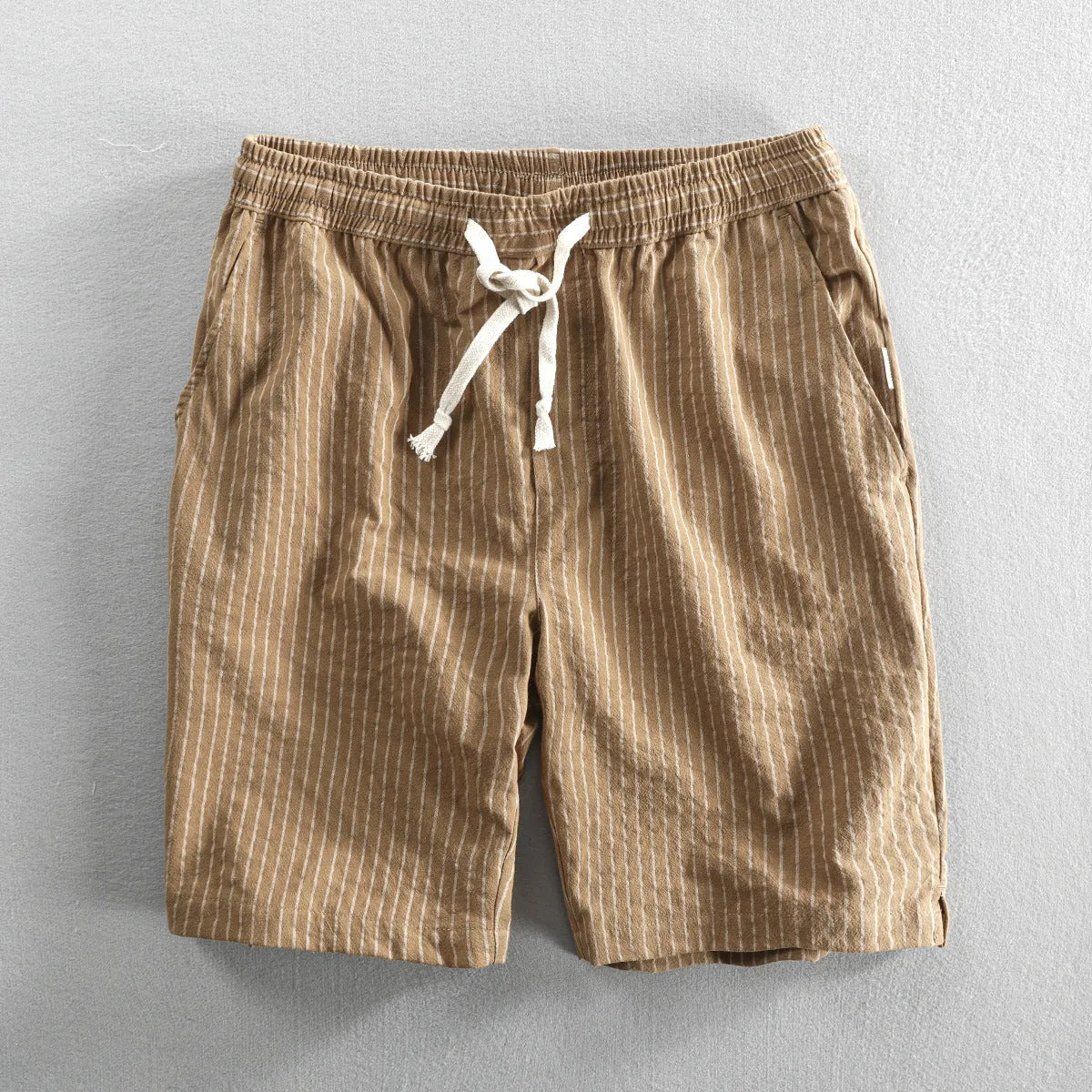 Man wearing black and white striped cotton casual shorts with a loose straight leg and elasticated waist.