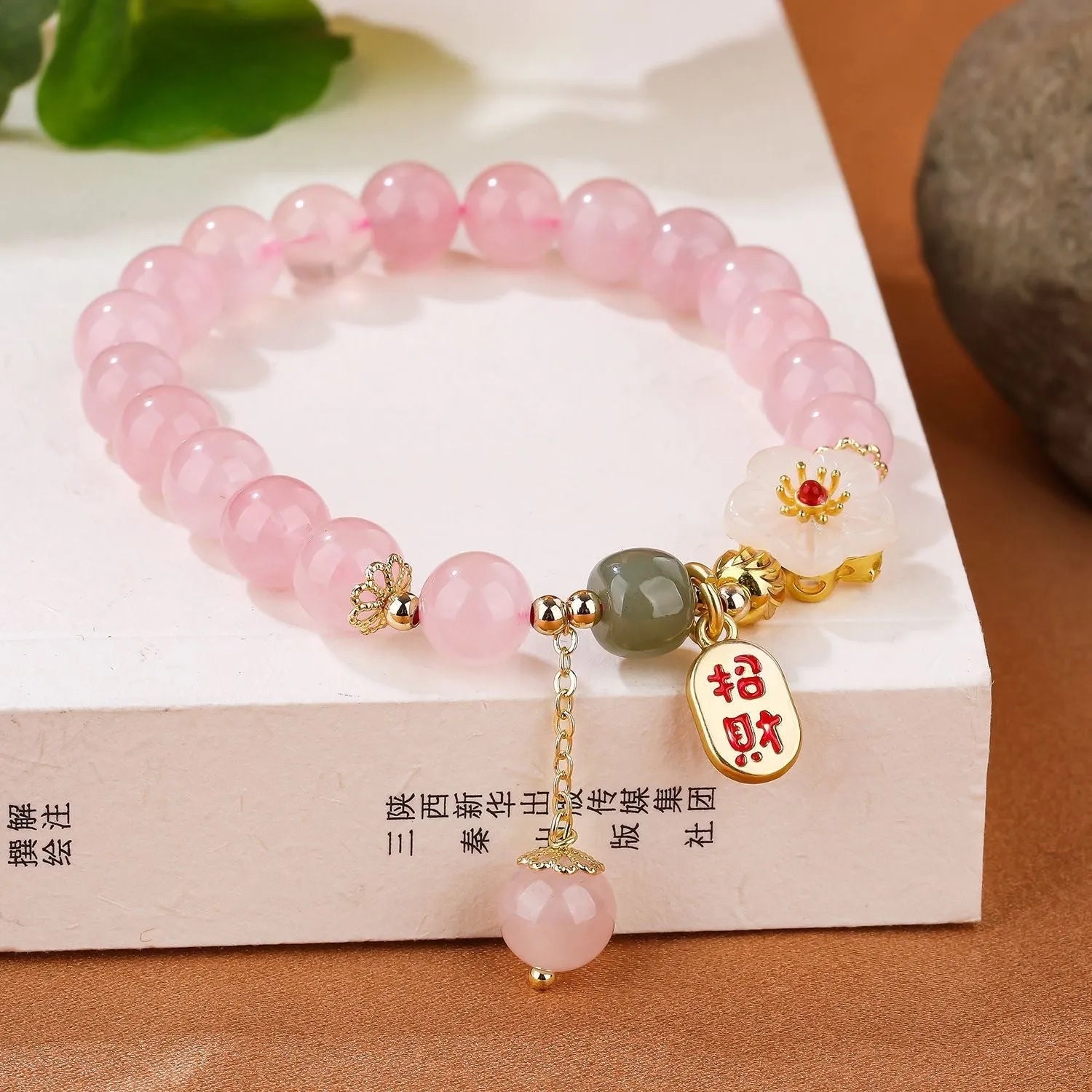 Aquamarine crystal bracelet with mixed materials including pink beads, white pearls, and peach blossom elements