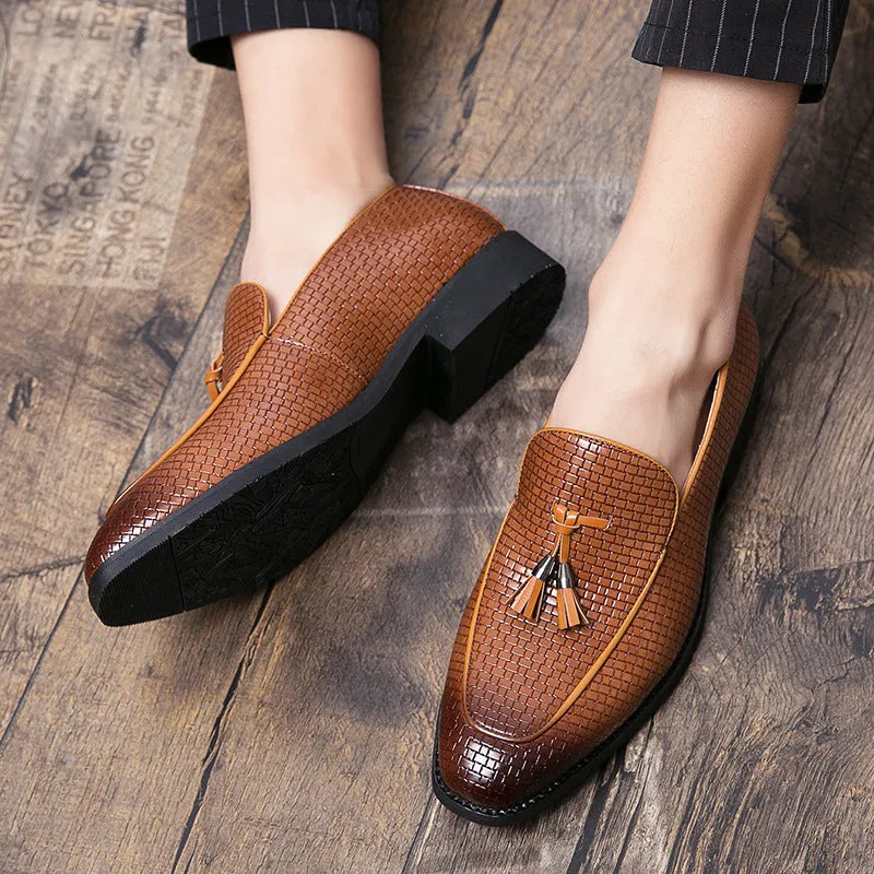 Men's black pointed slip-on business shoes with tassel detail on artificial PU upper.